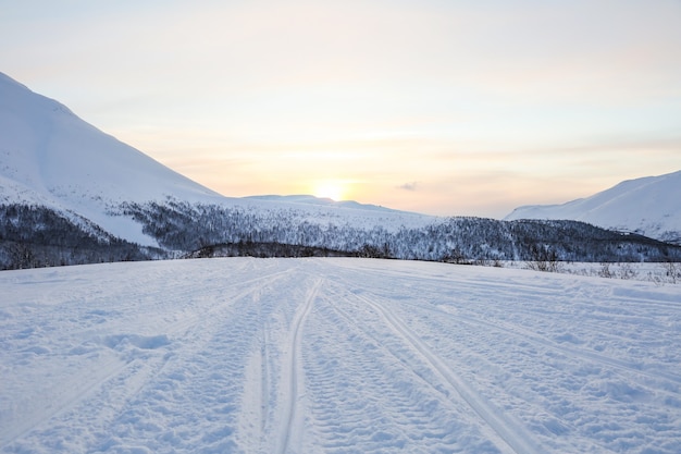 pistes de motoneige sur la neige dans les montagnes