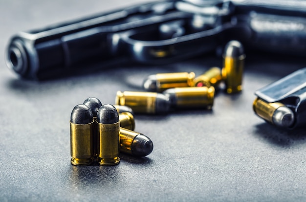 Pistolet de 9 mm et balles éparpillées sur la table.