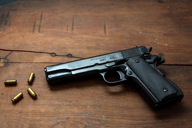 Pistolet 9mm et munitions sur table en bois Vue latérale de l'arme métallique automatique