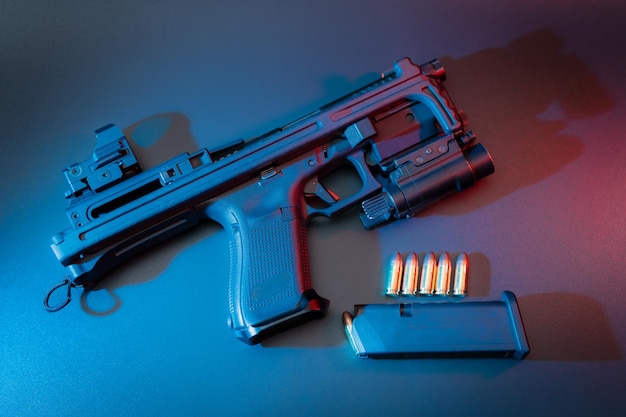 Un pistolet bleu et rouge est sur une table avec un fond bleu.