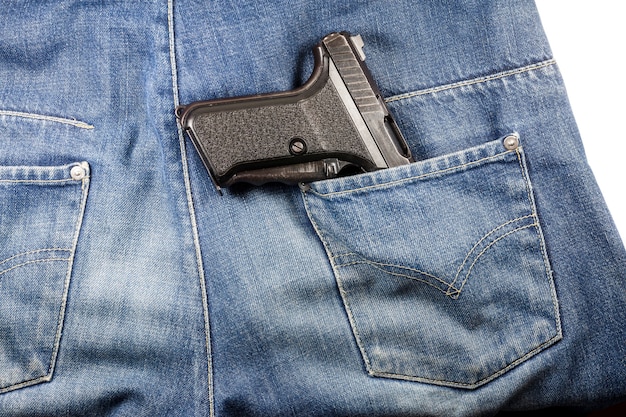 Pistolet dans la poche d'un jean.