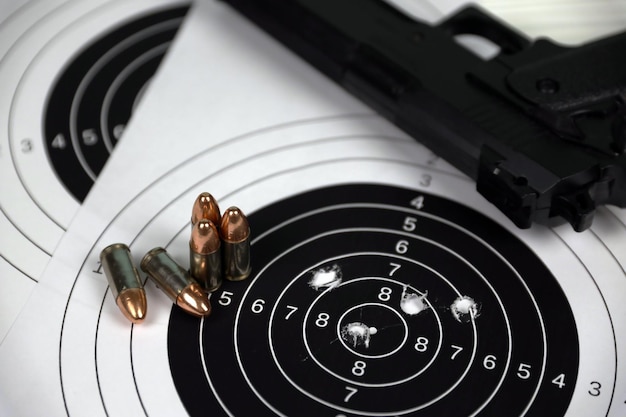 Pistolet et de nombreuses balles tirant des cibles sur une table blanche dans un polygone de champ de tir Entraînement pour viser et tirer