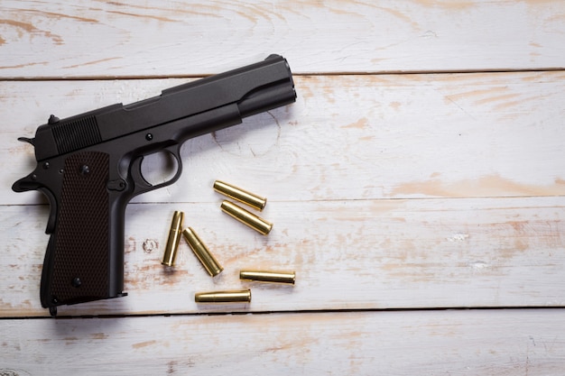 Photo pistolet avec des ronds sur le bureau en bois