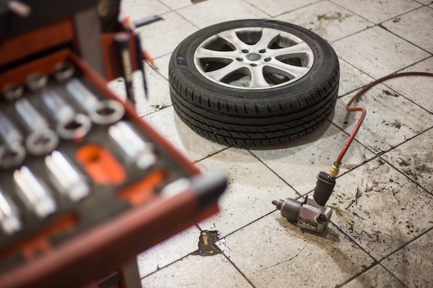 Photo pistolet à vide pour remplacer les roues de la voiture sur le sol, concept de transport