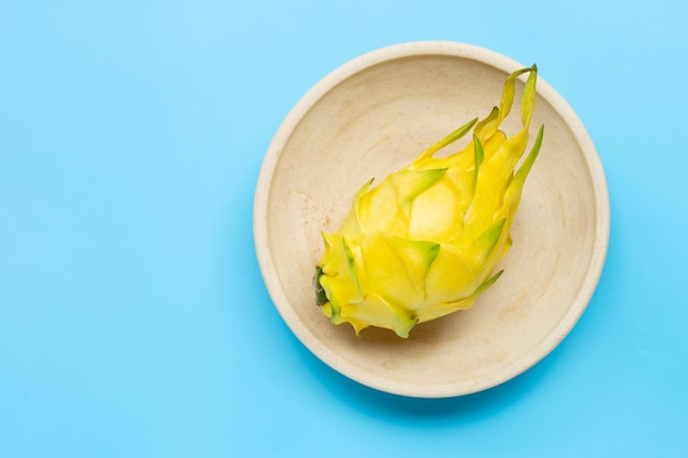 Pitahaya jaune ou fruit du dragon sur plaque sur table bleue