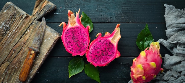 Pitahaya rouge sur fond noir. Dragon aux fruits. Fruits tropicaux. Vue de dessus. Espace libre pour le texte.