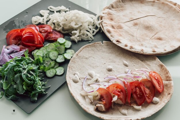 Pitta de style méditerranéen préparé avec une salade de tomates au concombre de poulet épicé et une sauce mayo une cuisine savoureuse