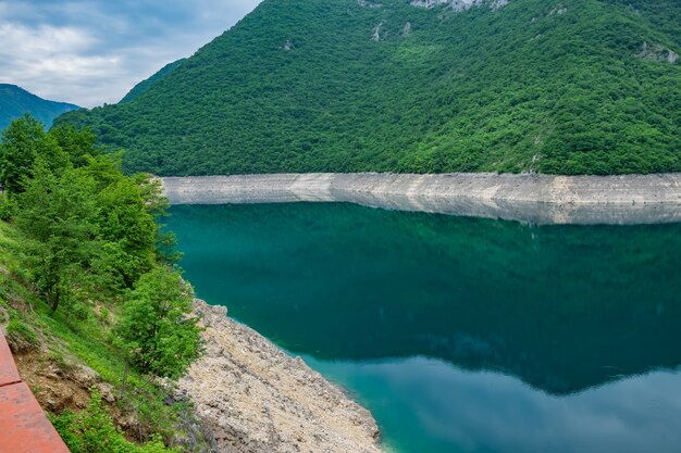 Le pittoresque lac turquoise est parmi les hautes montagnes.