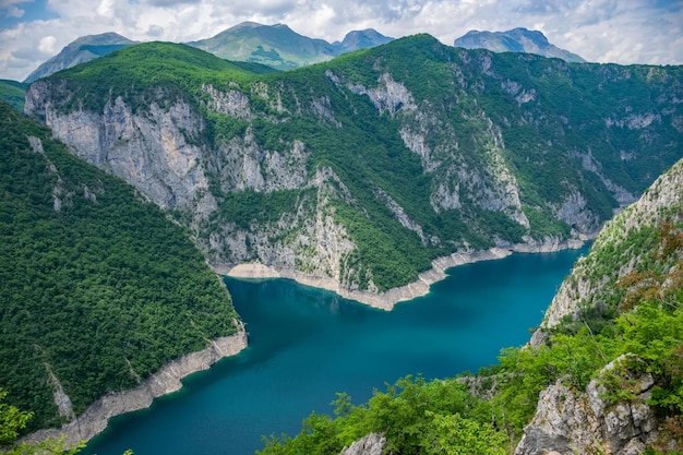 Un pittoresque lac turquoise peut être vu du haut d'une haute montagne