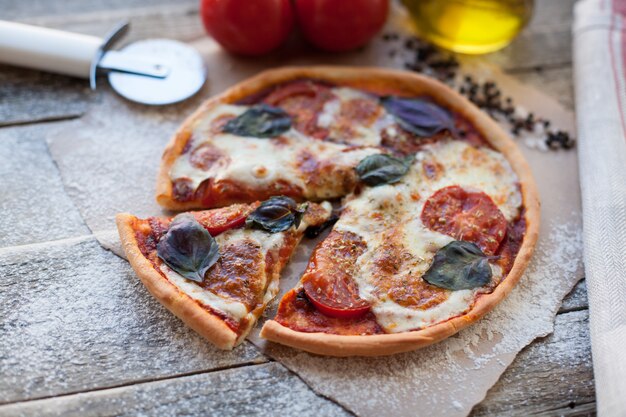 Pizza appétissante Margarita sur une table en bois.