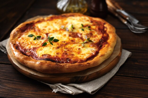 Pizza appétissante Margherita sur fond de bois foncé