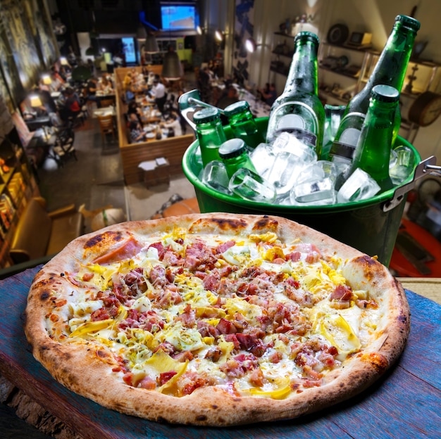 Pizza au bacon, bière dans un seau à glace à la pizzeria