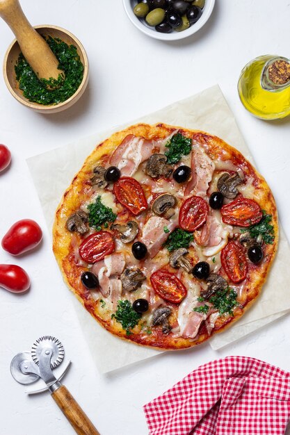 Pizza au bacon, champignons, tomates, fromage et olives. Nourriture italienne.
