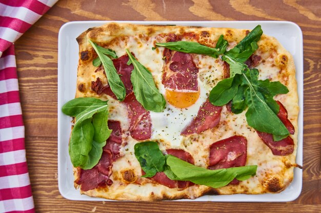 Pizza au bacon sur la table en bois