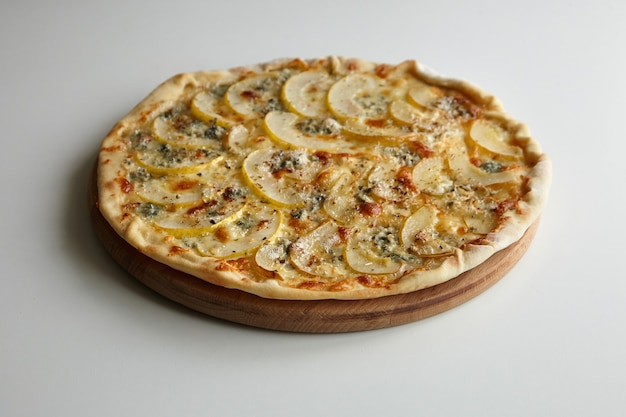 Pizza au fromage et aux poires sur une planche à découper en bois