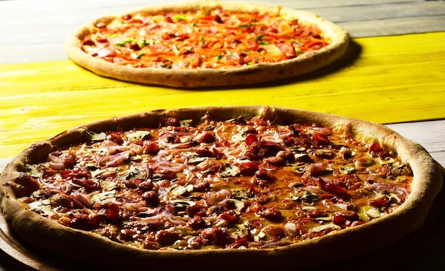 Pizza au fromage bacon et câpres sur fond de bois jaune