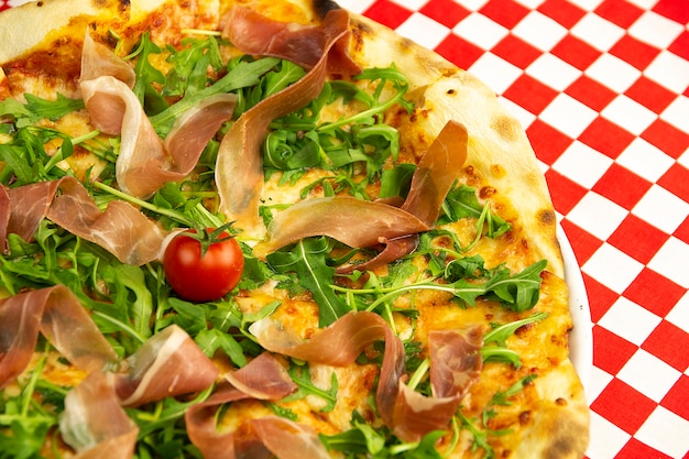 Pizza au jambon et roquette sur une table en bois