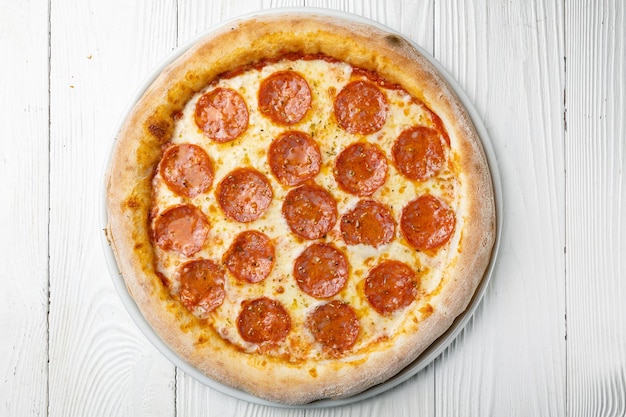 Une pizza au pepperoni dessus sur un tableau blanc