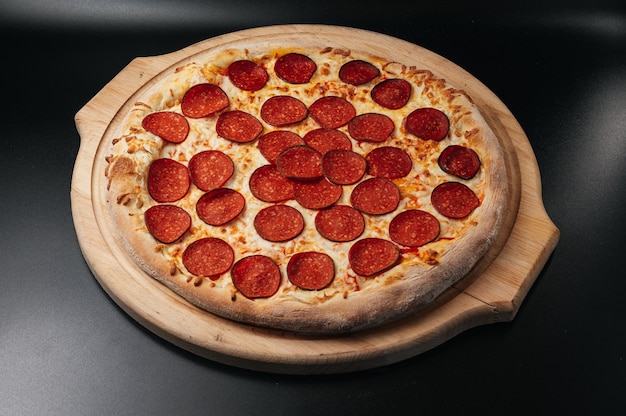 Pizza au pepperoni italien sur planche de bois