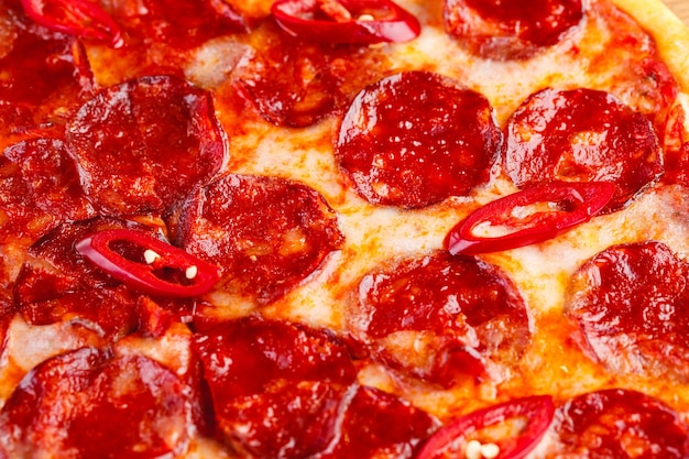 Pizza au pepperoni sur planche de bois sur fond sombre Gros plan