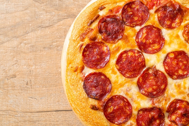 Pizza au pepperoni sur plateau en bois