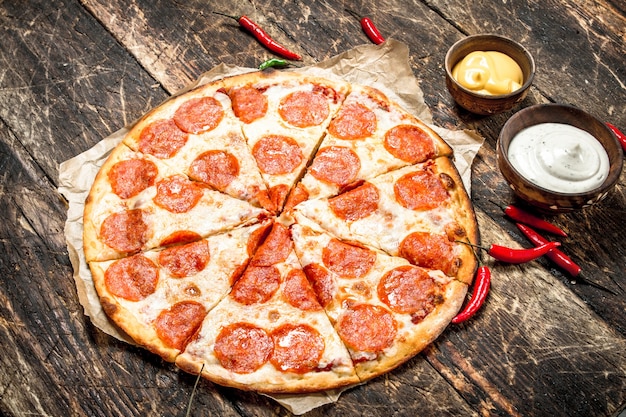 Pizza au pepperoni avec sauces.