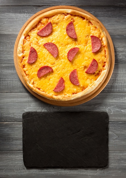 Pizza au pepperoni à table en bois