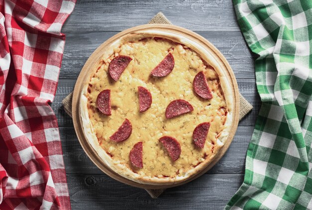 Pizza au pepperoni à table en bois