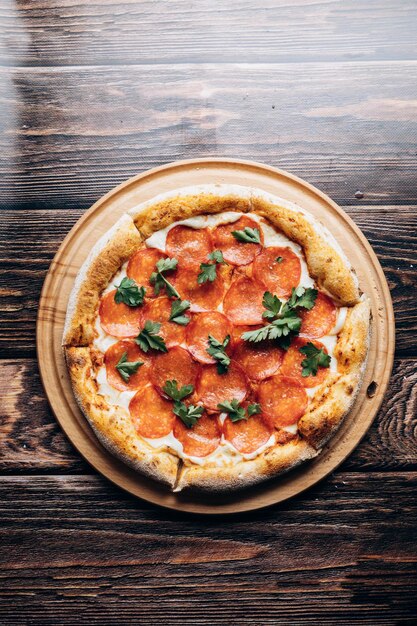 Une pizza au pepperoni sur une table en bois.