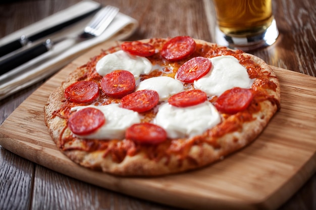 Pizza au pepperoni avec verre à bière Photo de haute qualité