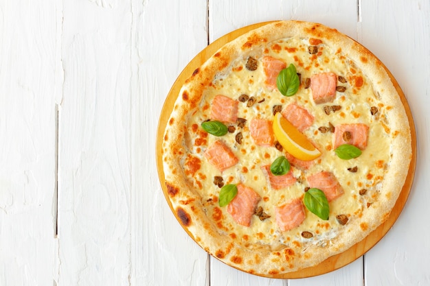 Photo pizza au saumon cuit sur table en bois