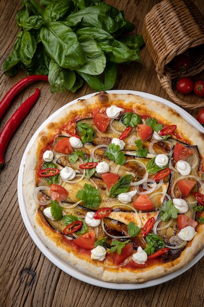 pizza aux aubergines, fromage, tomates et piments dans un restaurant