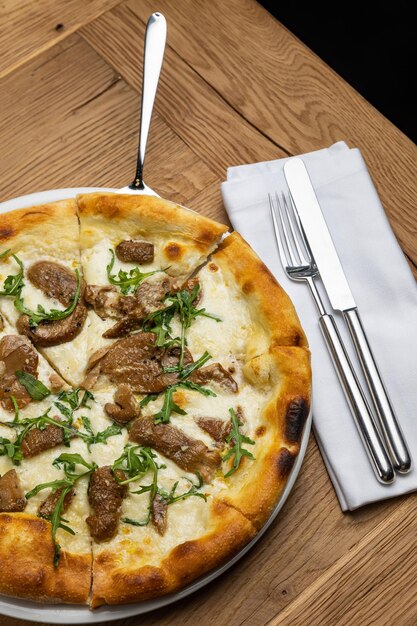 Une pizza aux champignons émincés et oignons verts