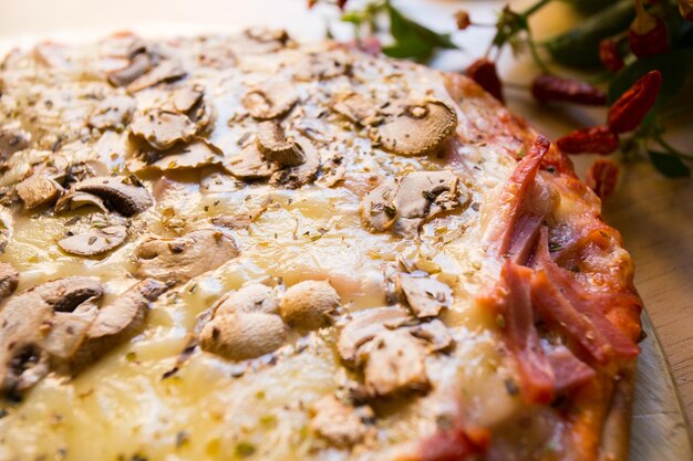 Photo pizza aux champignons. pizza napolitaine avec sauce tomate, fromage, jambon et champignons. recette italienne authentique