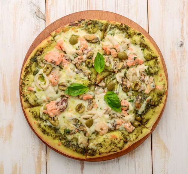 Pizza aux crevettes, saumon et olives, pesto