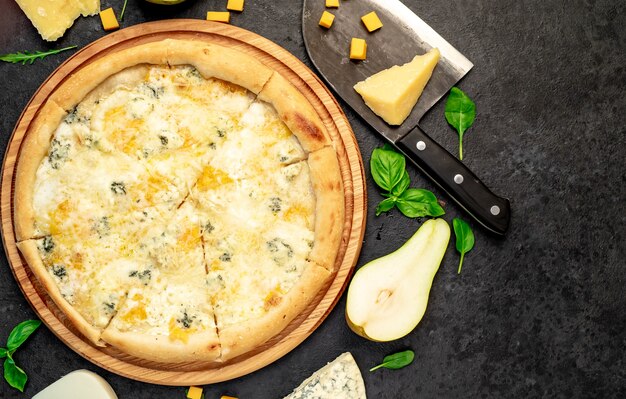 Photo pizza aux quatre fromages avec des ingrédients sur fond de pierre avec espace de copie pour votre texte