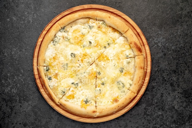 pizza aux quatre fromages avec des ingrédients sur fond de pierre