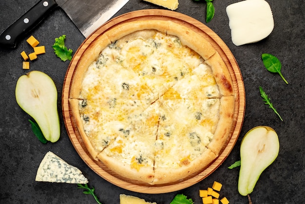 pizza aux quatre fromages avec des ingrédients sur fond de pierre