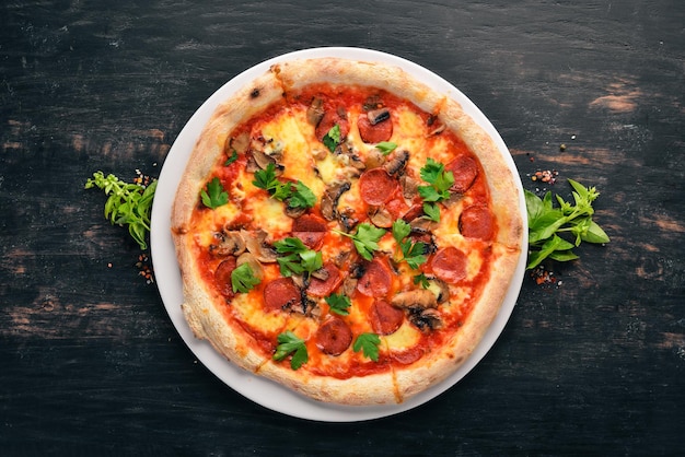 Pizza aux saucisses bavaroises champignons et fromage mozzarella Sur un fond en bois Vue de dessus Espace de copie gratuit