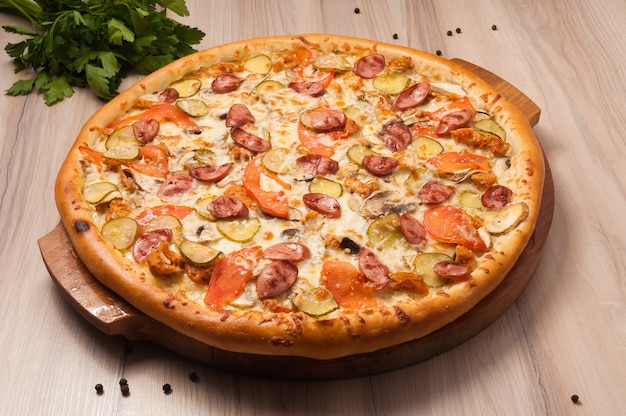 Pizza aux saucisses, concombres, tomates et champignons