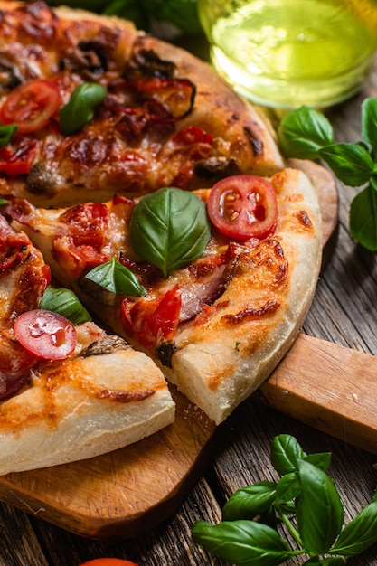 Une pizza aux tomates et au fromage sur une planche de bois