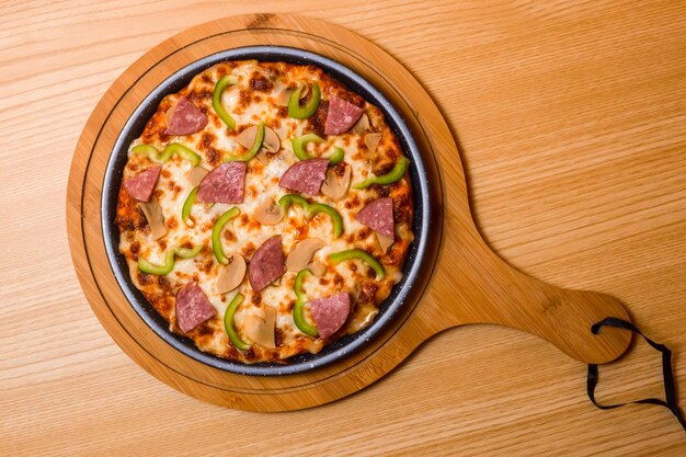 Pizza boeuf Encantos servi dans une planche à découper en bois isolée sur la vue de dessus de table de restauration rapide italienne