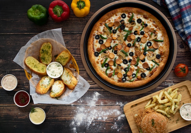 Pizza avec Burger, pain à l'ail sur table en bois, vue de dessus