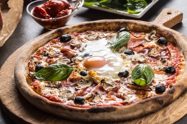 Pizza capricciosa repas italien de prosciutto champignons artichauts oeuf parmesan olives et basilic