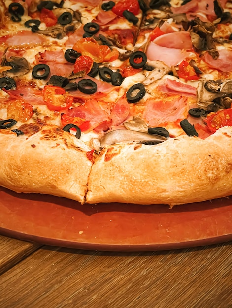 Pizza capriciosa avec croûte farcie au fromage dans une pizzeria