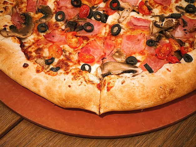 Pizza capriciosa avec croûte farcie au fromage dans une pizzeria