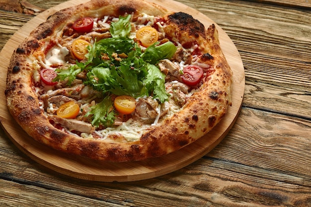 Pizza César Pizza au poulet, tomate, fromage et laitue sur planche de bois Vue de dessus Espace libre pour votre texte Livraison de nourriture
