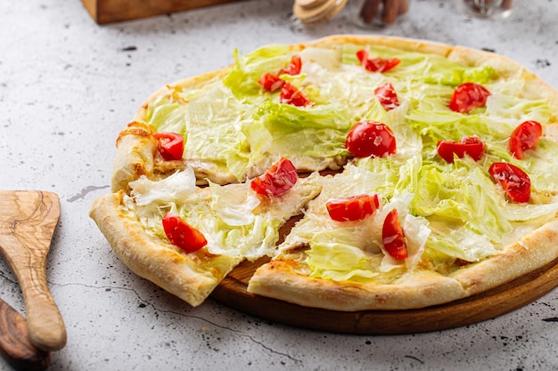 Pizza César avec salade iceberg et tomates