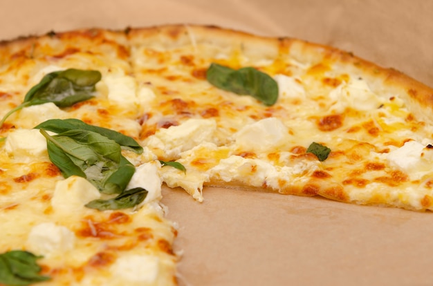 Pizza chaude avec du fromage et des feuilles de basilic.