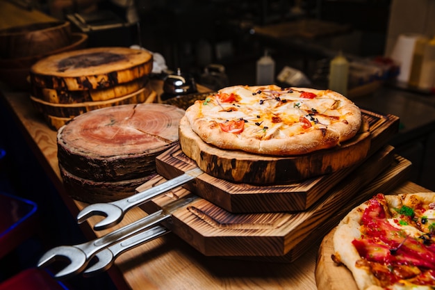 Une pizza chaude prête à être servie se trouve sur une planche à pizza en bois